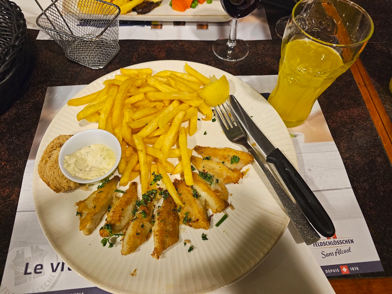 Assiette de poisson pané, frites et sauce tartare.