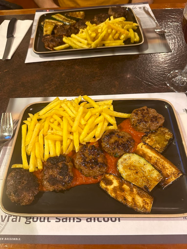 Assiette de grillades avec frites et légumes rôtis.