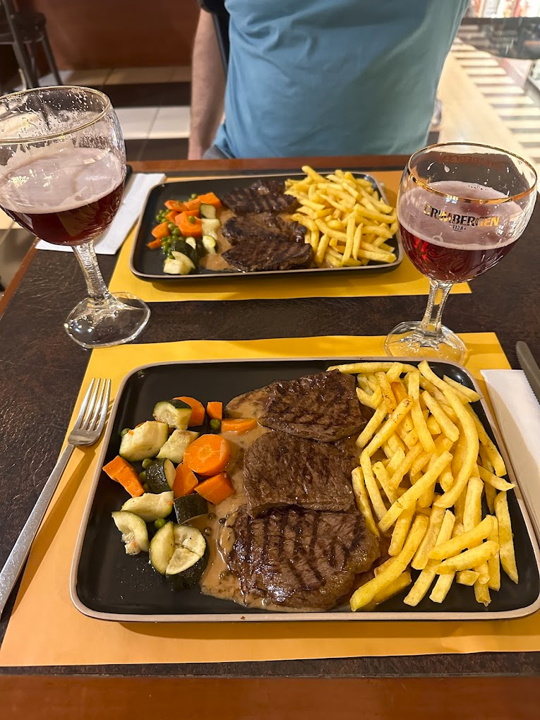 Deux assiettes de steak grillé avec frites et légumes.